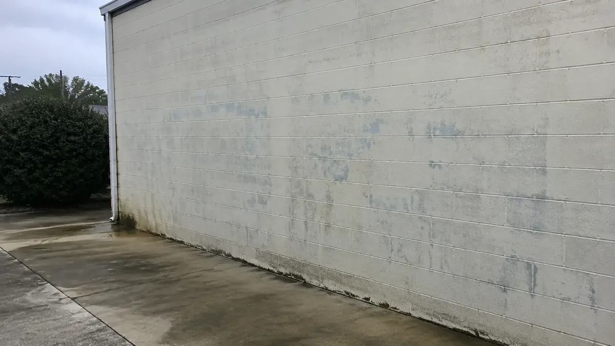 Faded graffiti remaining on a concrete-block wall after removal in South Georgia