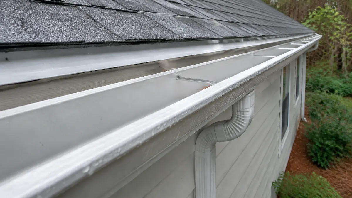 Clean white rain gutter mounted along the roof eave of a South Georgia home